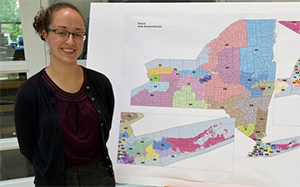 student stands in front of a map of new york state